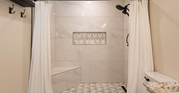 Full shower view with white curtain and decorative tilework by M&G Construction in Reno home.