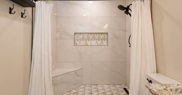 Full shower view with white curtain and decorative tilework by M&G Construction in Reno home.