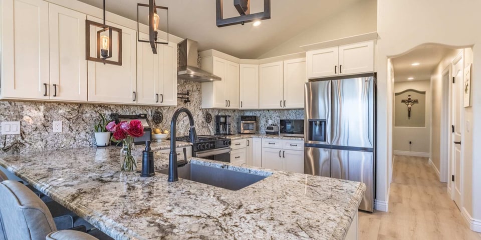 Image of kitchen remodel with granite countertops, white cabinets, and stainless steel appliances in Reno, NV by M&G Construction