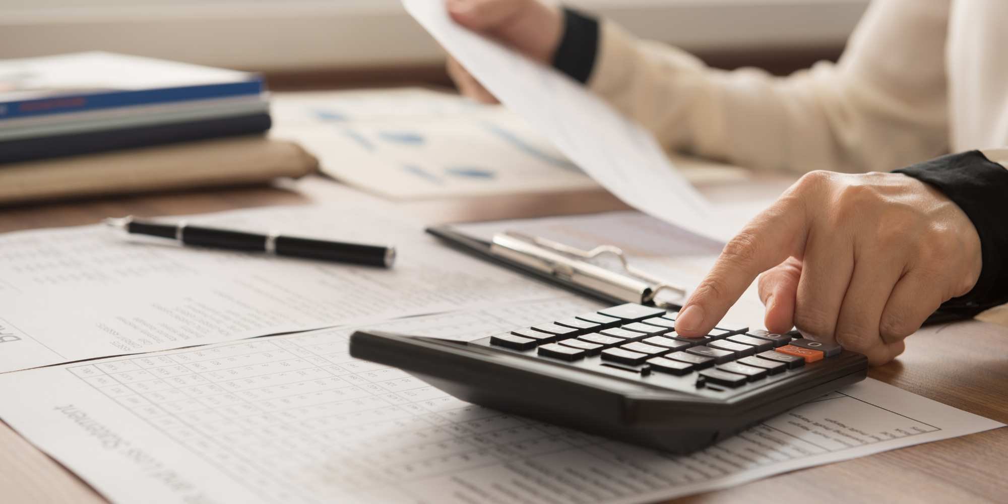 Stock image of a person setting a budget with a calculator and paper for a kitchen remodel in Reno, NV