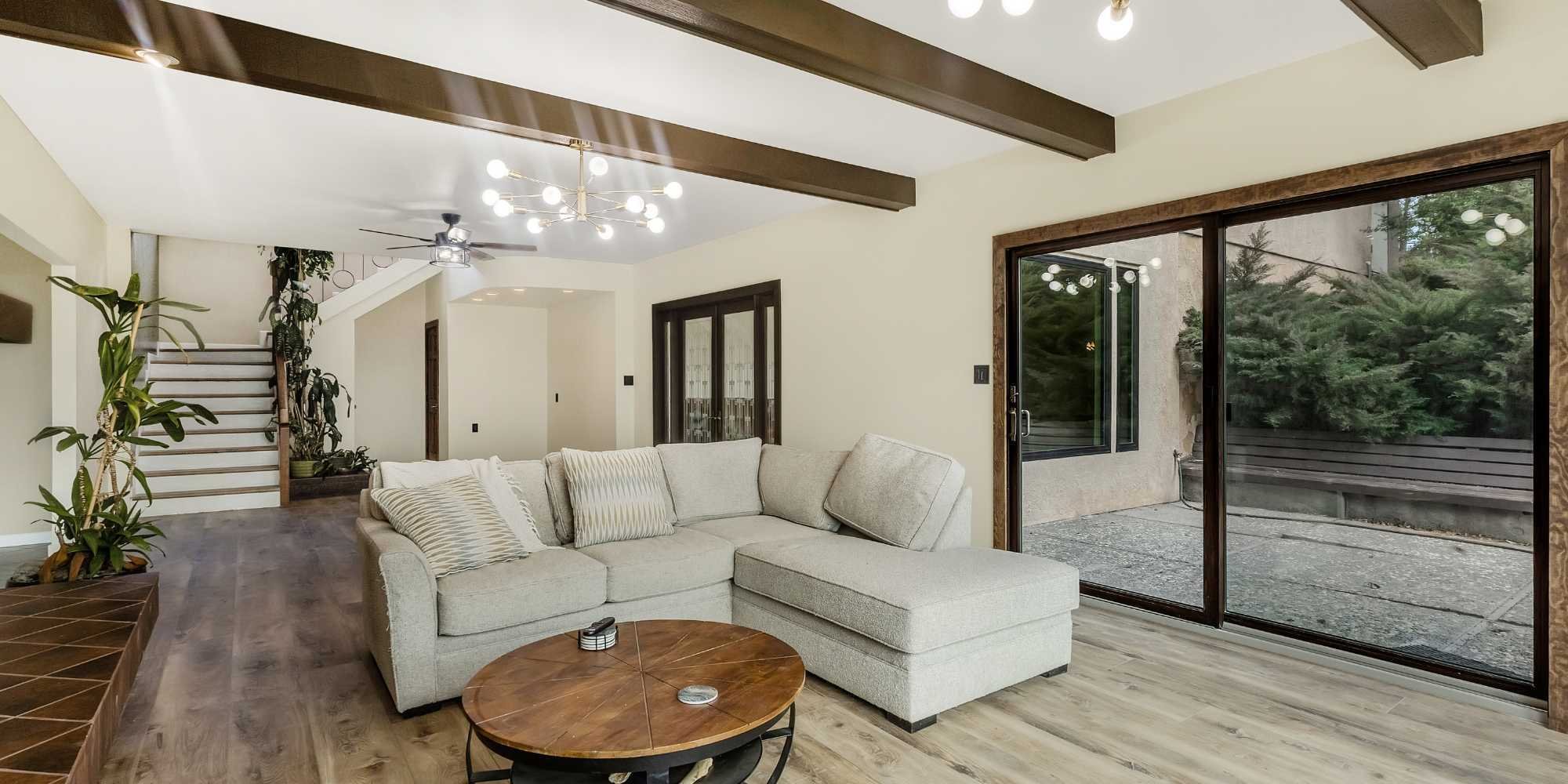 Modern living room remodel in Reno, NV by M&G Construction with sectional seating, wood floors, and indoor-outdoor access