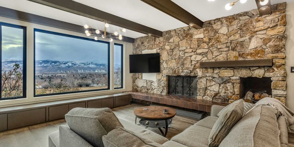 Living room remodel with a stone-feature fireplace and wood beams by M&G Construction, Reno