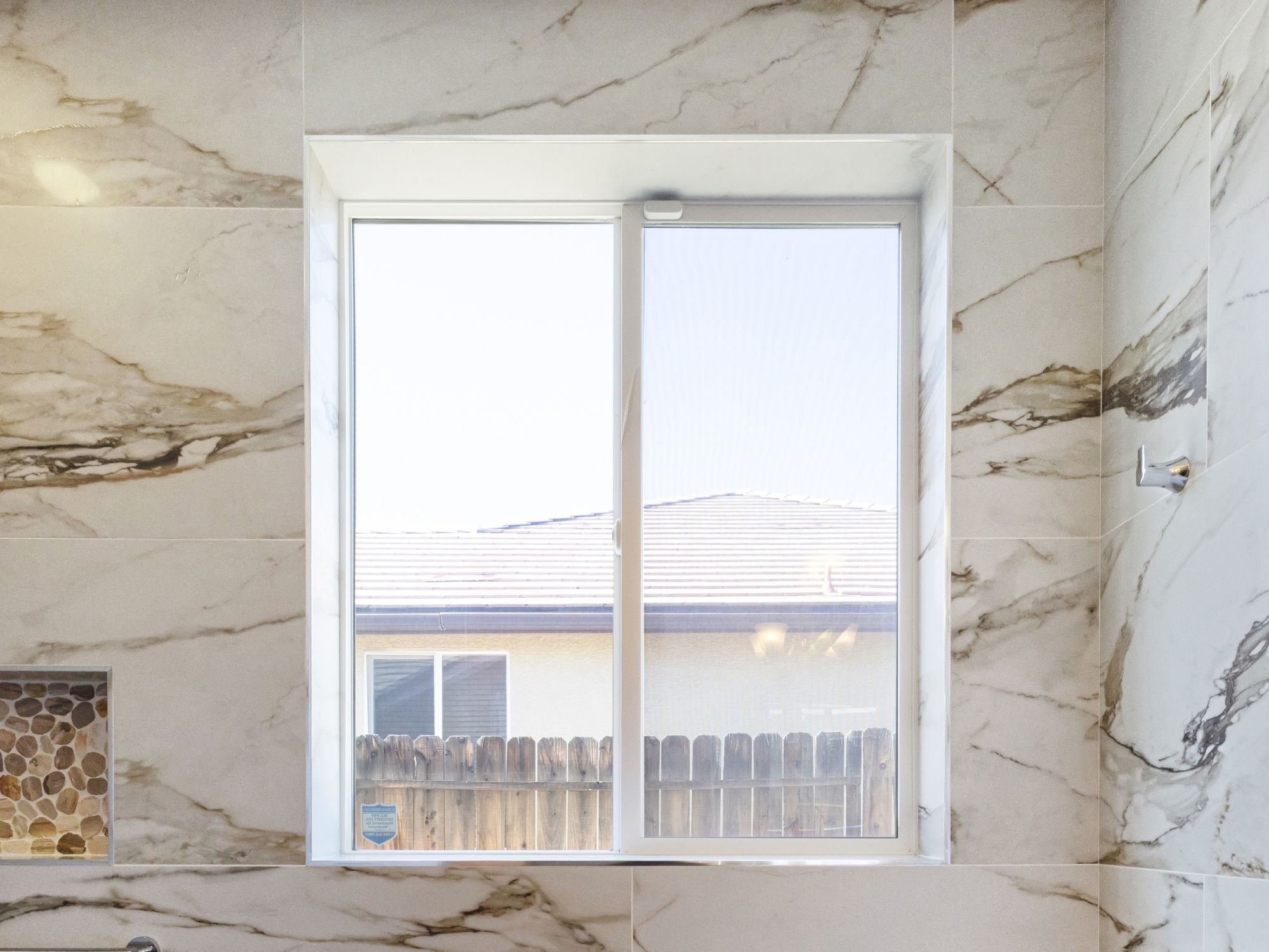 Existing window preserved in a Northwest Reno primary bathroom remodel by M&G Construction fills the space with natural light
