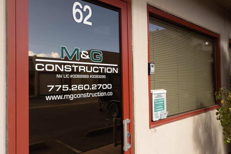 M&G Construction front office door with business branding and contact info in Carson City, Nevada.