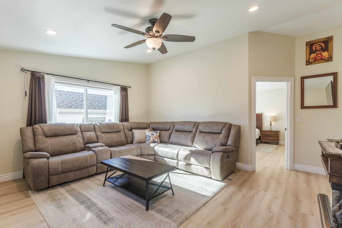Corner view of furnished living room with window and sectional sofa in M&G Construction custom home, Reno, NV.