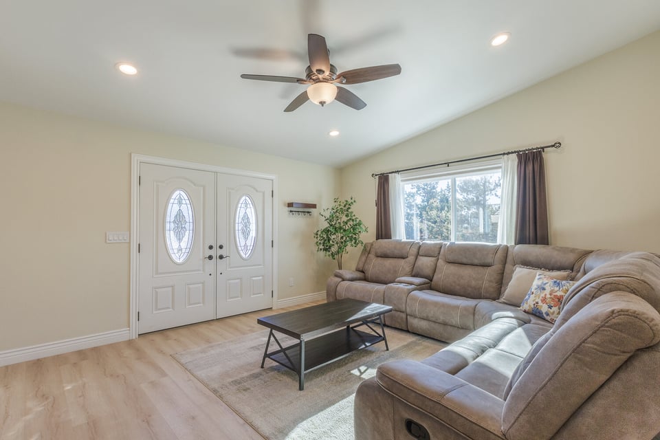 Furnished living room with plush couch and double doors in a Reno custom home built by M&G Construction.