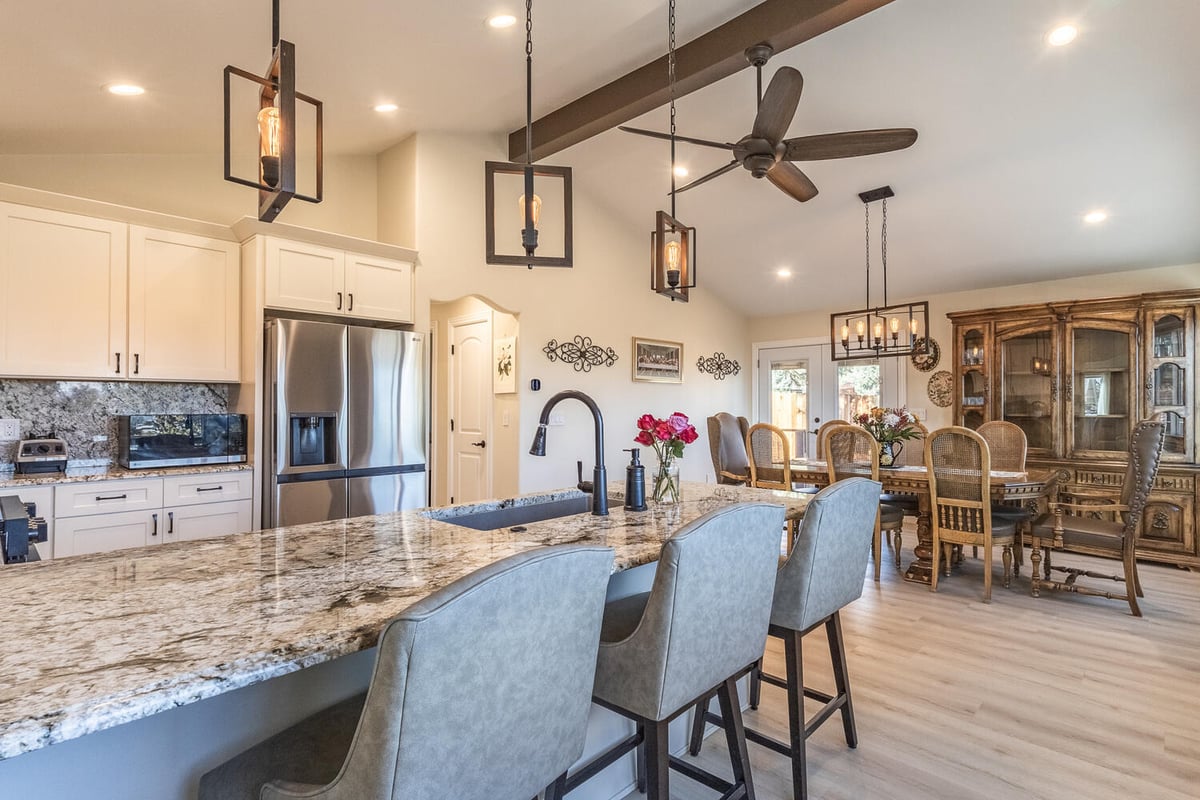 High-end custom kitchen and dining area with pendant lights and granite counters by M&G Construction in Reno, NV.