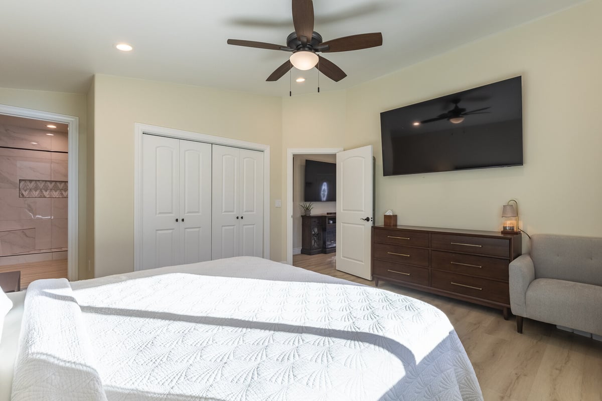 Master bedroom interior with mounted TV and modern decor in M&G Construction custom home, Reno, NV.