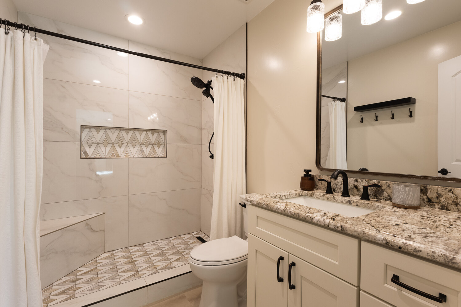 Renovated bathroom featuring granite vanity and walk-in shower with accent tile, built by M&G Construction, Reno.
