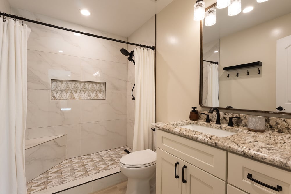 Modern bathroom remodel with patterned shower tile and granite vanity by M&G Construction in Reno, NV.