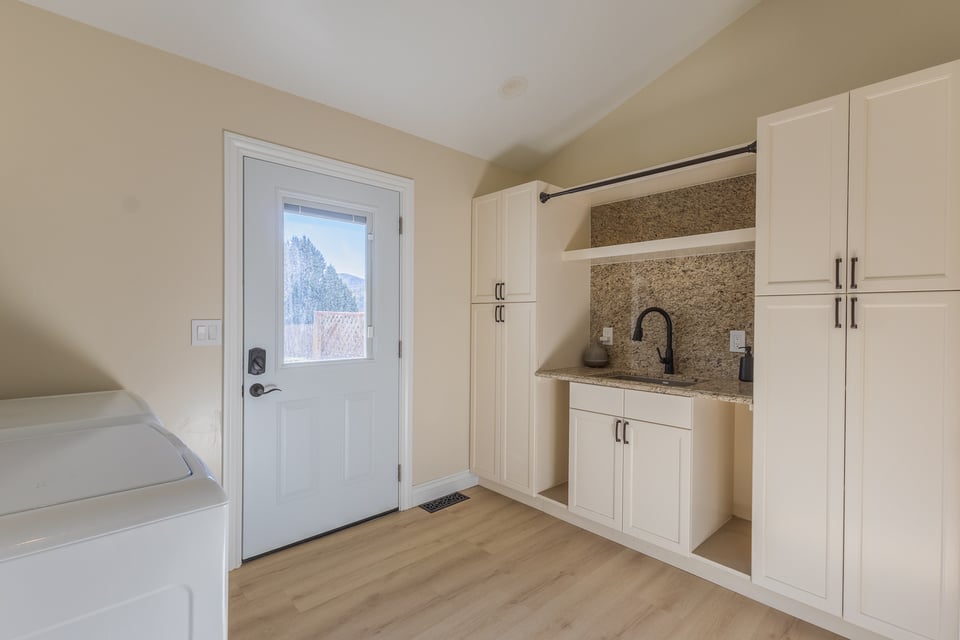 Custom laundry room with granite countertops and white cabinetry by M&G Construction in Carson City, NV.