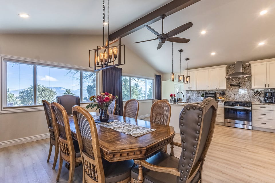 Open-concept kitchen and dining area with large windows and mountain views in Reno custom home by M&G Construction.