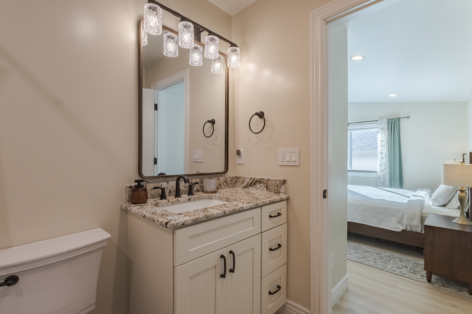 Custom vanity with granite countertop and stylish lighting in Reno bathroom remodel by M&G Construction.